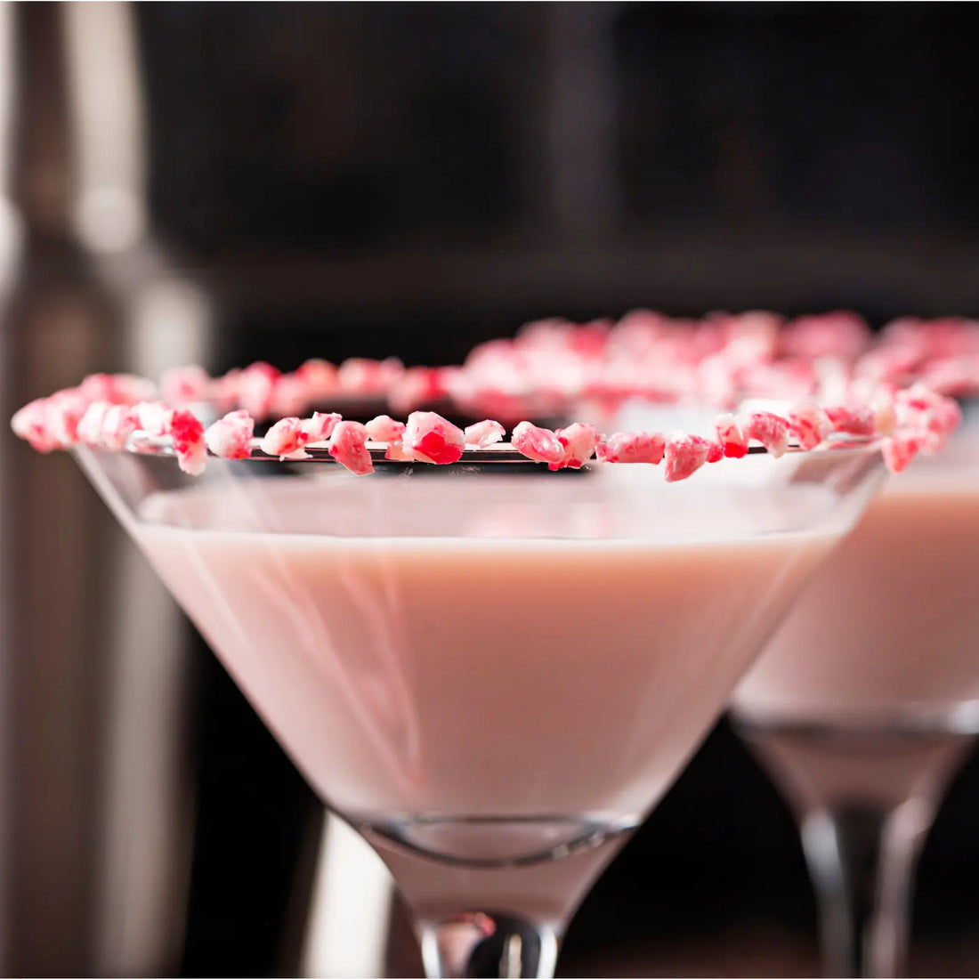 Close-up of a peppermint espresso martini with a crushed candy cane rim and soft holiday lighting