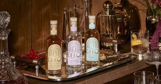 RTD cocktail enhancements shown with a trio of Deko bottles arranged stylishly on a mirrored tray.