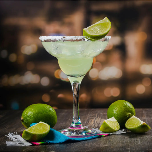 Low-sugar margarita in a salt-rimmed glass with lime wedges on a rustic table and a blurred bokeh backdrop