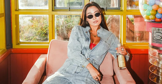 Classic bourbon cocktails bottle held by a stylish woman lounging in a retro café setting with bright window light