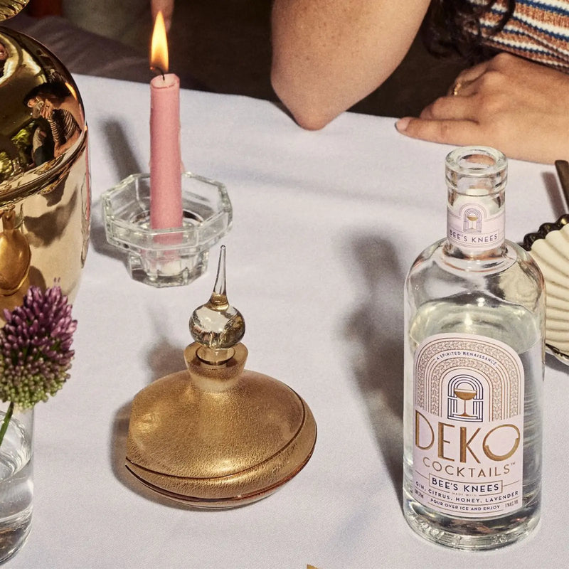 Deko Cocktails Bee's Knees bottled gin cocktail on a candlelit table setting.