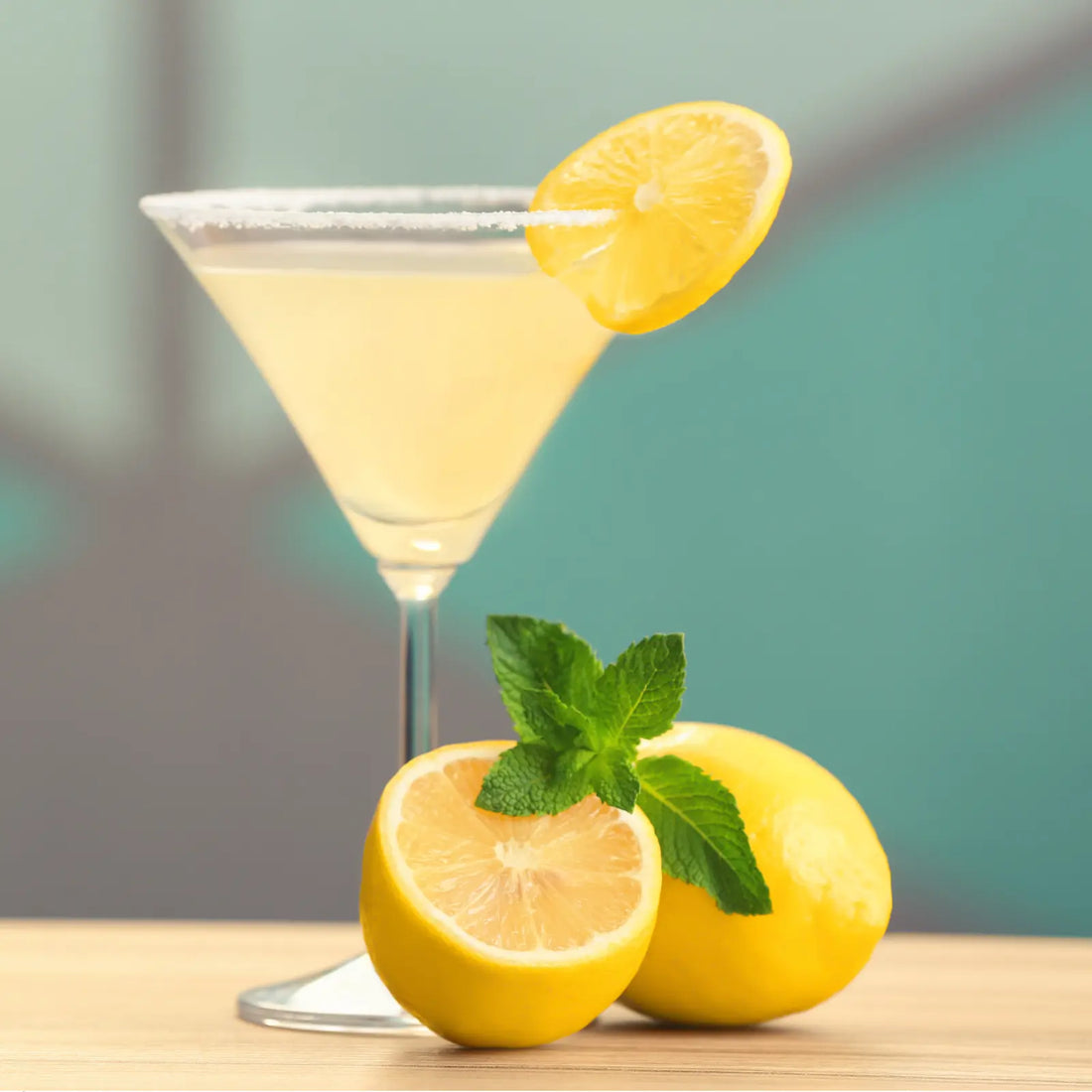 Classic lemon drop martini in a sugar-rimmed glass, garnished with a lemon slice and fresh mint.