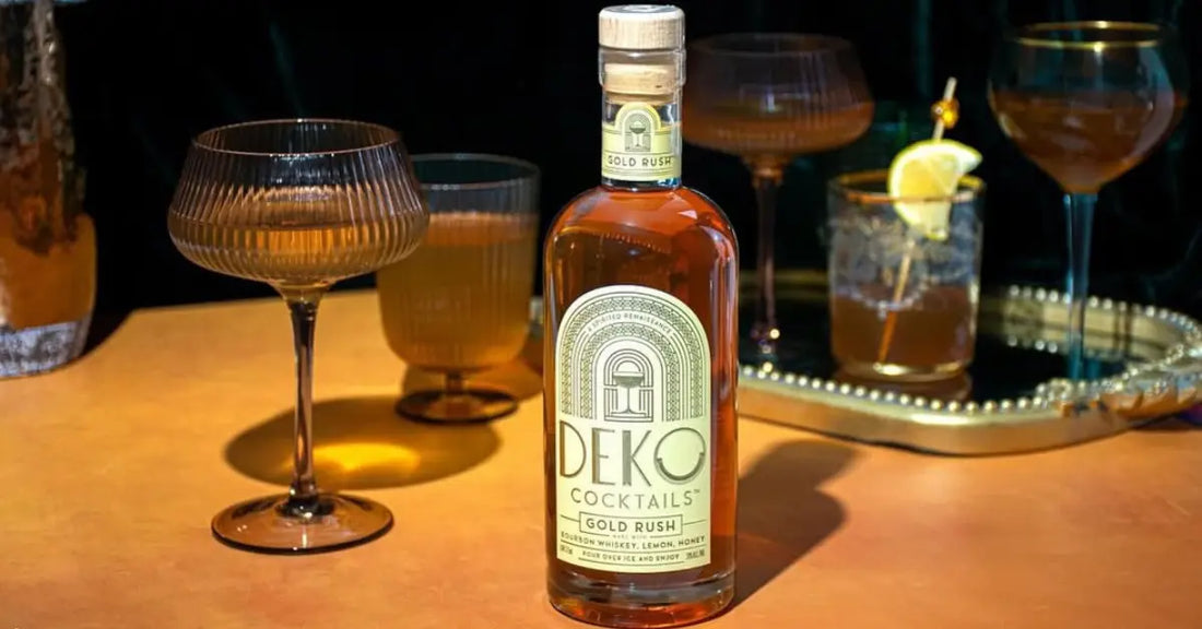 Small-batch cocktails like Deko’s Gold Rush elegantly served in vintage glassware on a golden table.