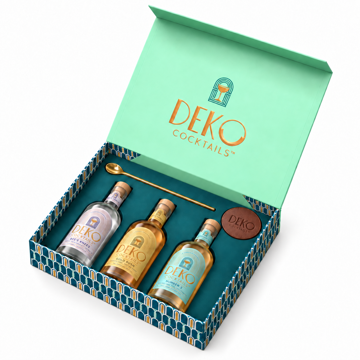 Deko Cocktails Gift Box open, showing Bee's Knees, Gold Rush and Number 3 with a gold cocktail bar spoon and vegan leather coasters.